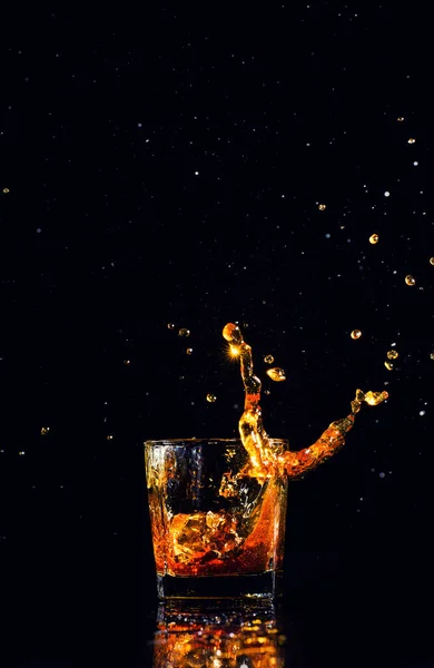 Colpo isolato di whisky con spruzzata su sfondo nero — Foto Stock