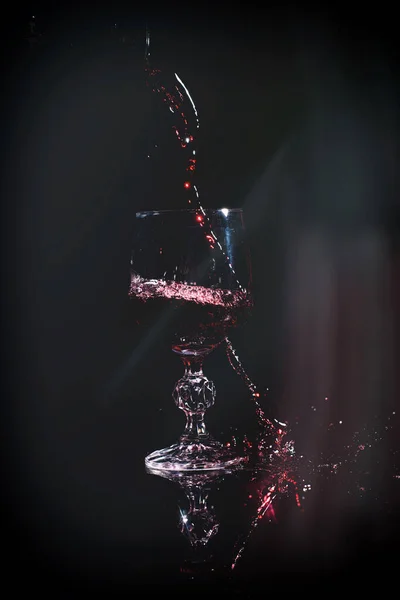 Vinho tinto derramando em copo de vinho — Fotografia de Stock