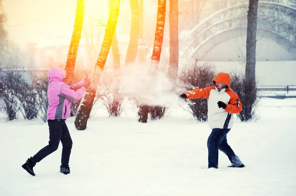Bataille de boules de neige. Couple d'hiver s'amuser à jouer dans la neige en plein air — Photo