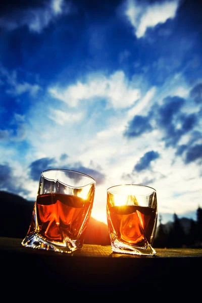 Whisky bei Sonnenuntergang dramatischen Himmel auf Berglandschaft Hintergrund — Stockfoto