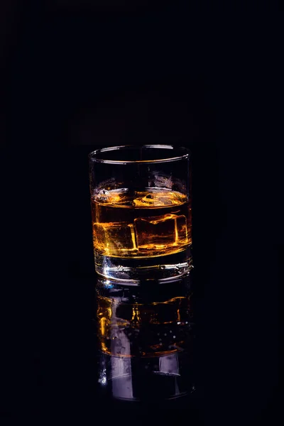 Odosobniony strzał whisky na czarnym tle, brandy w szklance — Zdjęcie stockowe