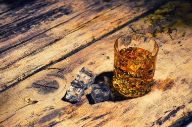 Arkaplanda buz küpleri olan viski.