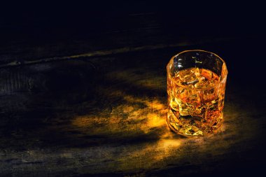 Arkaplanda buz küpleri olan viski.