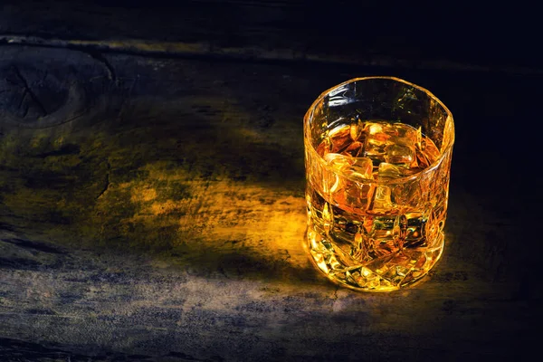 Whiskey with ice cubes on wooden background — Stock Photo, Image