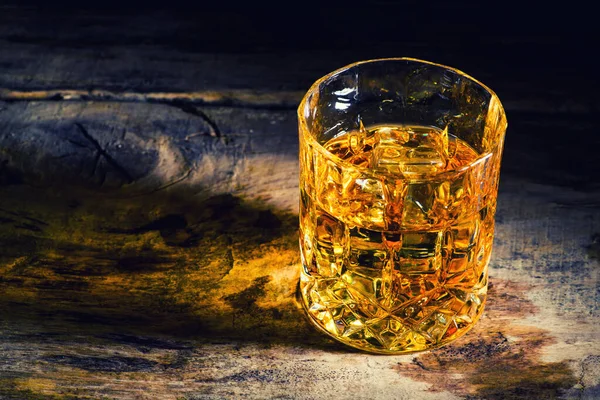 Whiskey with ice cubes on wooden background — Stock Photo, Image