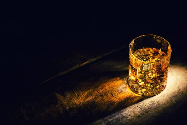 Whiskey with ice cubes on wooden background — Stock Photo, Image