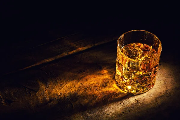 Whiskey with ice cubes on wooden background — Stock Photo, Image