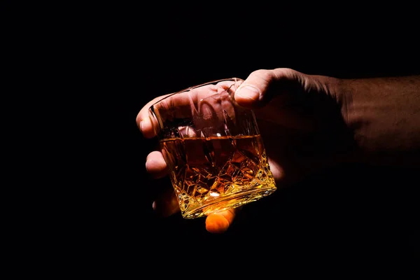 Un vaso de whisky en la mano de un hombre —  Fotos de Stock