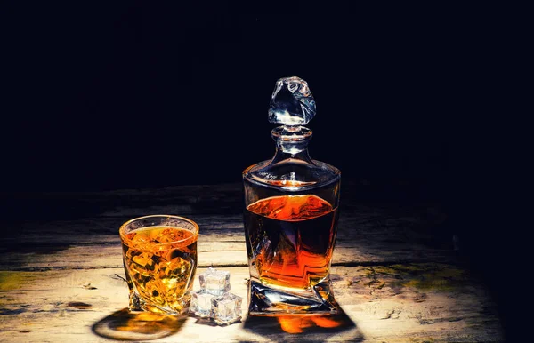 Whiskey with ice cubes on wooden background — Stock Photo, Image