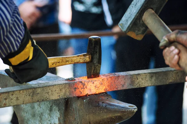 Heavy hammer blows on a hot iron, old fashioned blacksmith furna — Stock Photo, Image