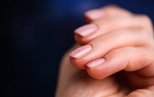 Desenho de unhas. Mãos com manicure nu brilhante no fundo escuro — Fotografia de Stock