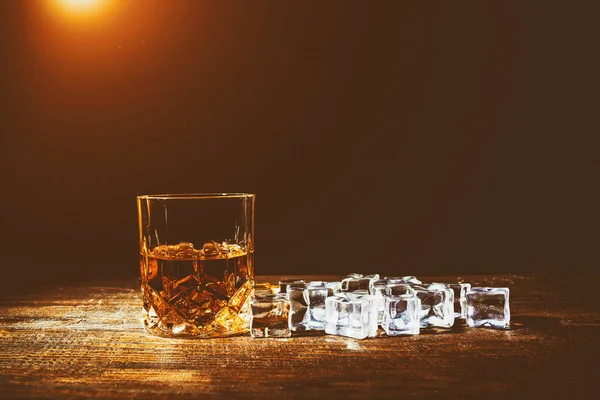 Whisky s kostkami ledu na dřevěném pozadí — Stock fotografie
