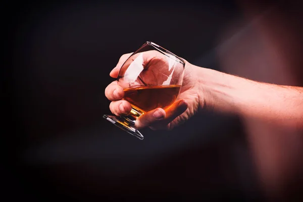 Vaso de coñac en la mano de un hombre — Foto de Stock