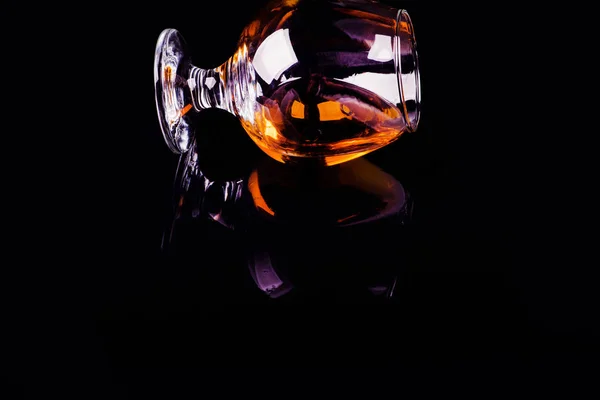 Kaca dengan cognac pada latar belakang hitam — Stok Foto