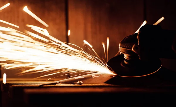 Metal grinding on steel pipe with flash of sparks close up — Stock Photo, Image