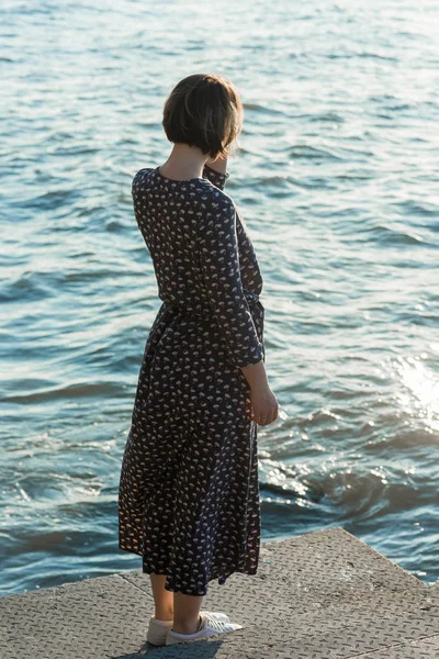 Belle fille dans une robe posant près de la mer — Photo