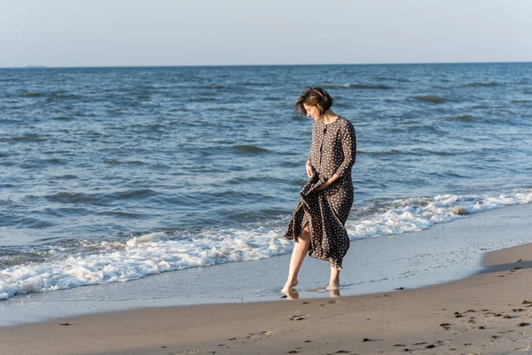 Belle fille dans une robe posant près de la mer — Photo