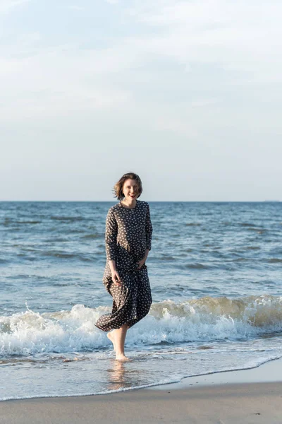 Belle fille dans une robe posant près de la mer — Photo