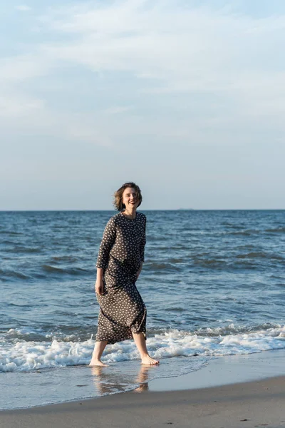 Belle fille dans une robe posant près de la mer — Photo