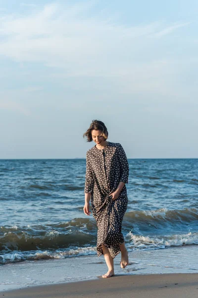 Belle fille dans une robe posant près de la mer — Photo