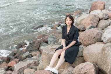 Güzel kız kayalar denize yakın oturur