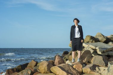 Güzel kız deniz kenarında siyah bir takım elbise poz