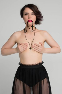 Güzel kız siyah bir haç ile çıplak poz
