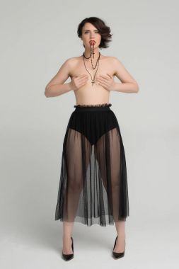 Güzel kız siyah bir haç ile çıplak poz