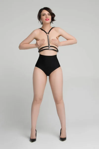Beautiful girl posing nude in black shorts — Stock Photo, Image