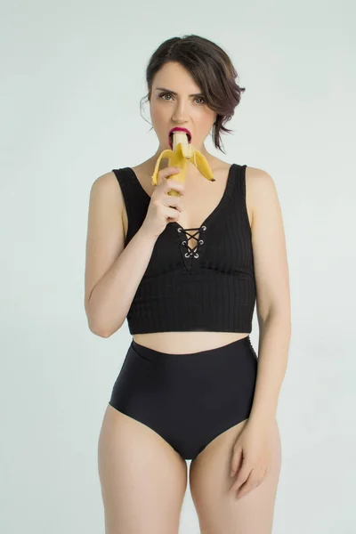 Fată într-un costum de baie cu o banană — Fotografie, imagine de stoc