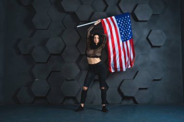 Studio siyah giysili gri arka plan üzerinde Amerikan bayrağıyla poz güzel kız