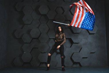 Studio siyah giysili gri arka plan üzerinde Amerikan bayrağıyla poz güzel kız