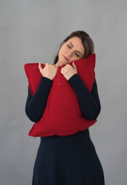 genç güzel kız Studio ile kırmızı yastık ayakta poz