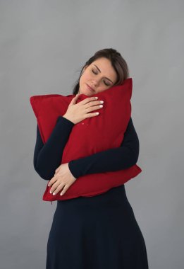 genç güzel kız Studio ile kırmızı yastık ayakta poz