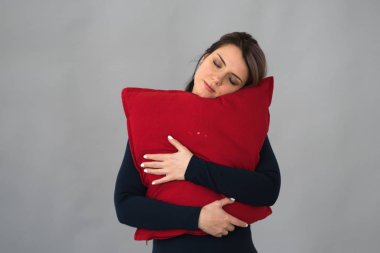 genç güzel kız Studio ile kırmızı yastık ayakta poz