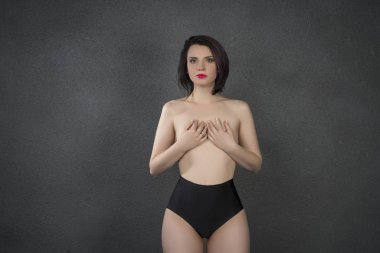 genç güzel kız Studio gri arka plan üzerinde siyah iç çamaşırı poz