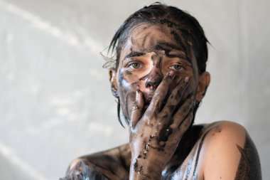 Genç ve güzel bir kızın yüzü siyaha boyanmış.