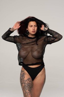 Stüdyoda siyah iç çamaşırlarıyla poz veren güzel bir kız.