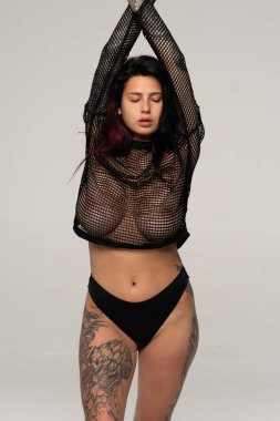 Stüdyoda siyah iç çamaşırlarıyla poz veren güzel bir kız.