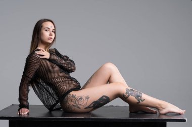 Stüdyoda siyah iç çamaşırlarıyla poz veren güzel bir kız.