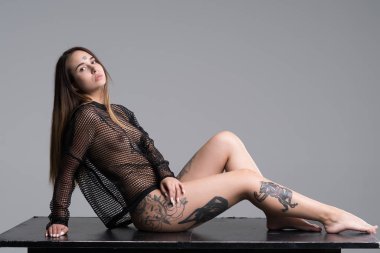 Stüdyoda siyah iç çamaşırlarıyla poz veren güzel bir kız.