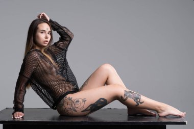 Stüdyoda siyah iç çamaşırlarıyla poz veren güzel bir kız.