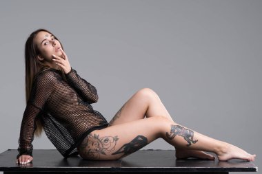 Stüdyoda siyah iç çamaşırlarıyla poz veren güzel bir kız.