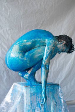 Mavili kız sandalyede oturuyor.