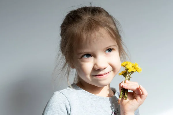 一个手里拿着黄色花朵的小女孩的画像 — 图库照片