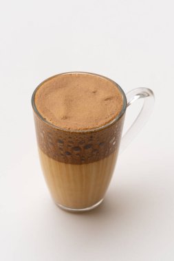 Kahverengi kahve standı olan şeffaf bir fincan.