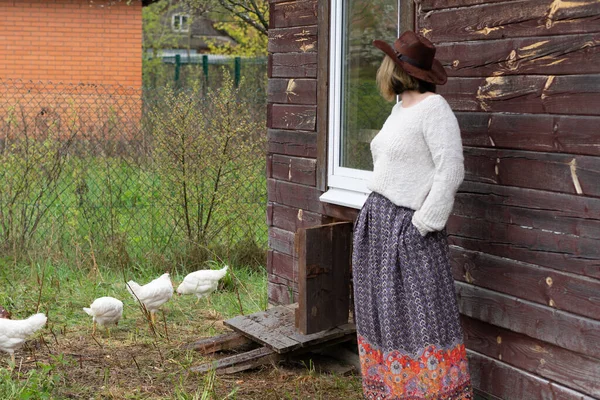一个乡村姑娘站在一个靠近小鸡的村子里 — 图库照片