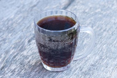 Masanın üzerinde koyu renkli bir kupa var.