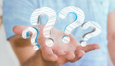 Elle çizilmiş soru işaretleri elinde tutan işadamı