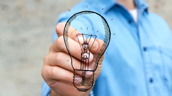 Бизнесмен рисует концепцию инновационных лампочек — стоковое фото